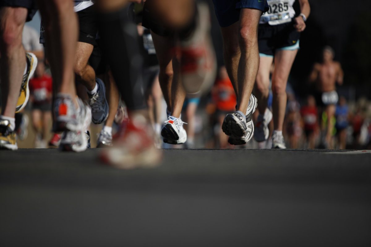 Runners crossing the start line of a road race